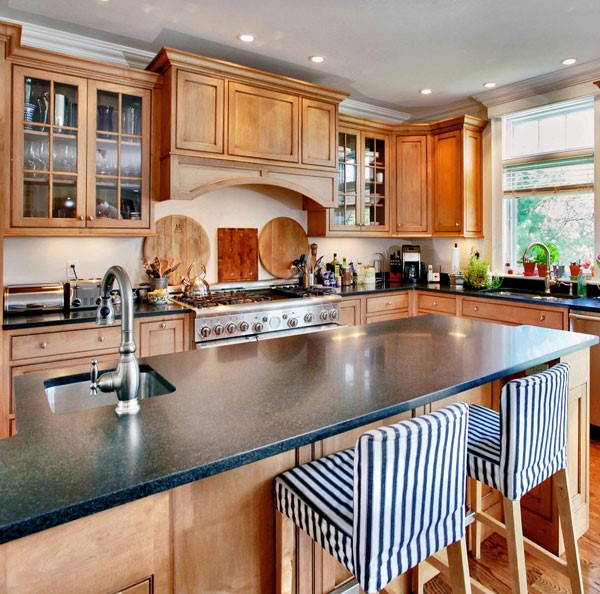 Light wood cabinets with black kitchen tops